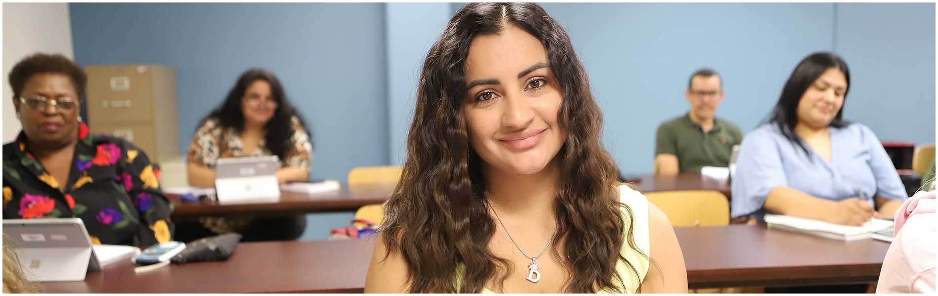 成人教育和扫盲计划 Classroom of students sitting at the table with laptops