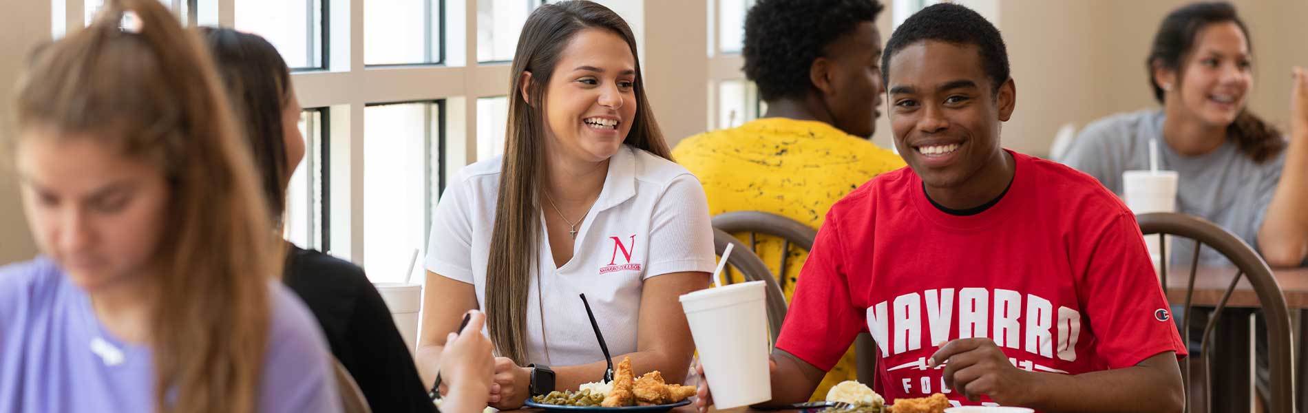 Students conversing and eating in cafeteria