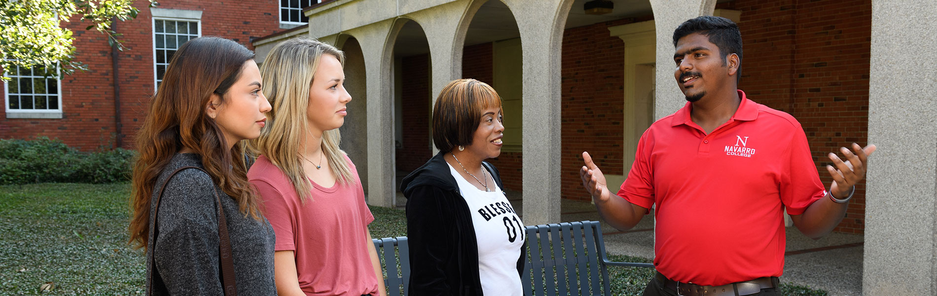 Walking Tour Recruiter talking to two prospective students and a chaperone.