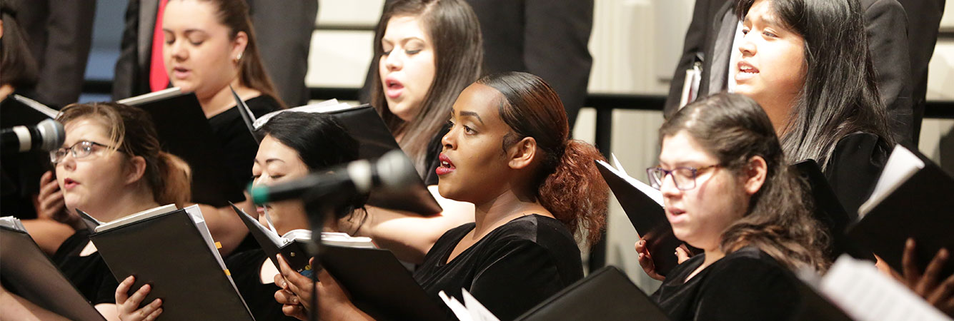 A group of choral singers holding music book and in performance