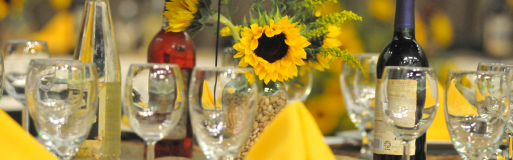 Table Setting table setting with yellow napkins, sunflowers, and wine glasses