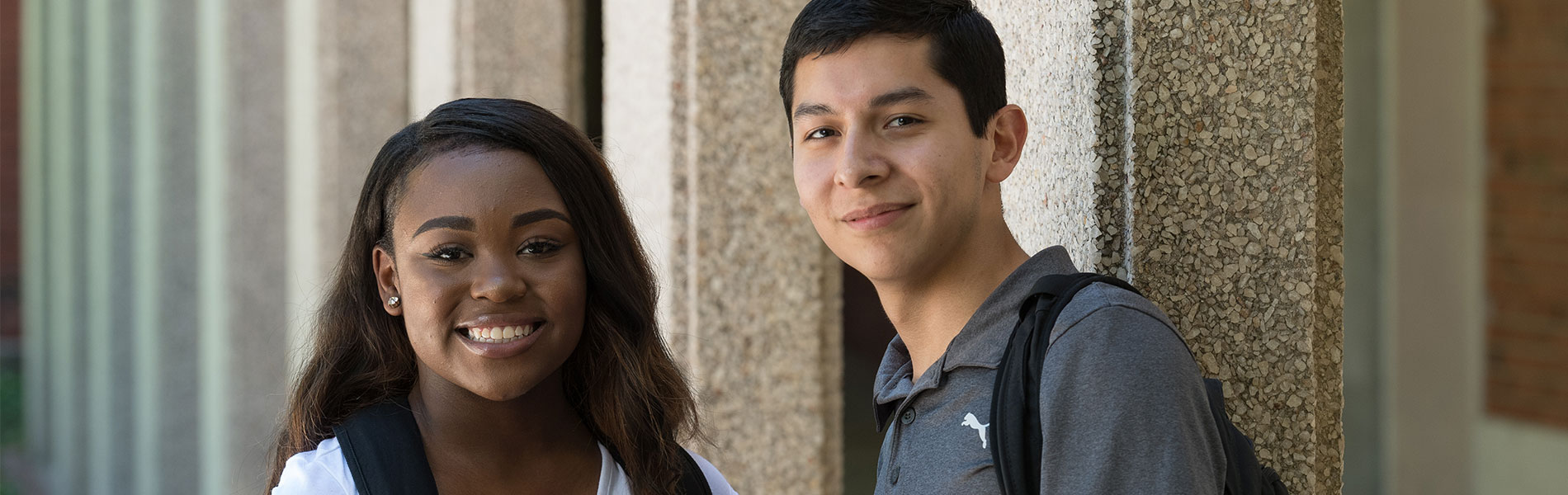 双重信用 Two 双重信用 students standing next to each other outside and smiling at the camera