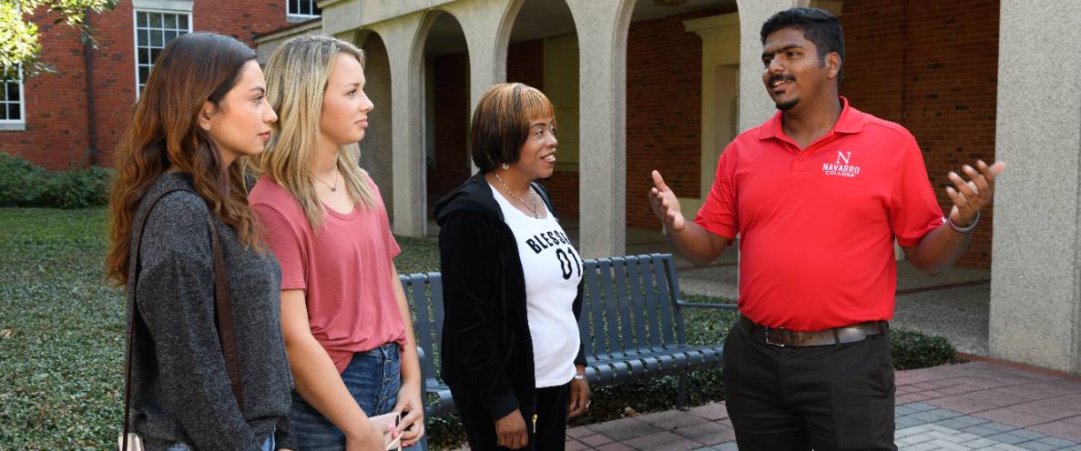 皇冠博彩College-Waxahachie Recruiter talking to two prospective students and a chaperone.