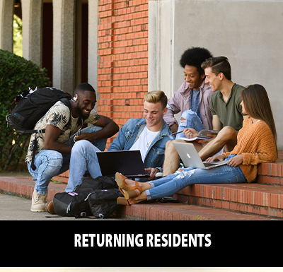Returning Residents Group of 5 students sitting on the steps of the building looking at a laptop