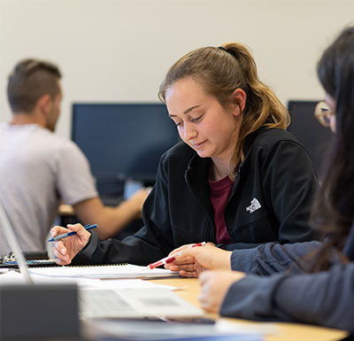 斗牛犬的生活 Students in tutoring lab, studying and looking over notes at the table