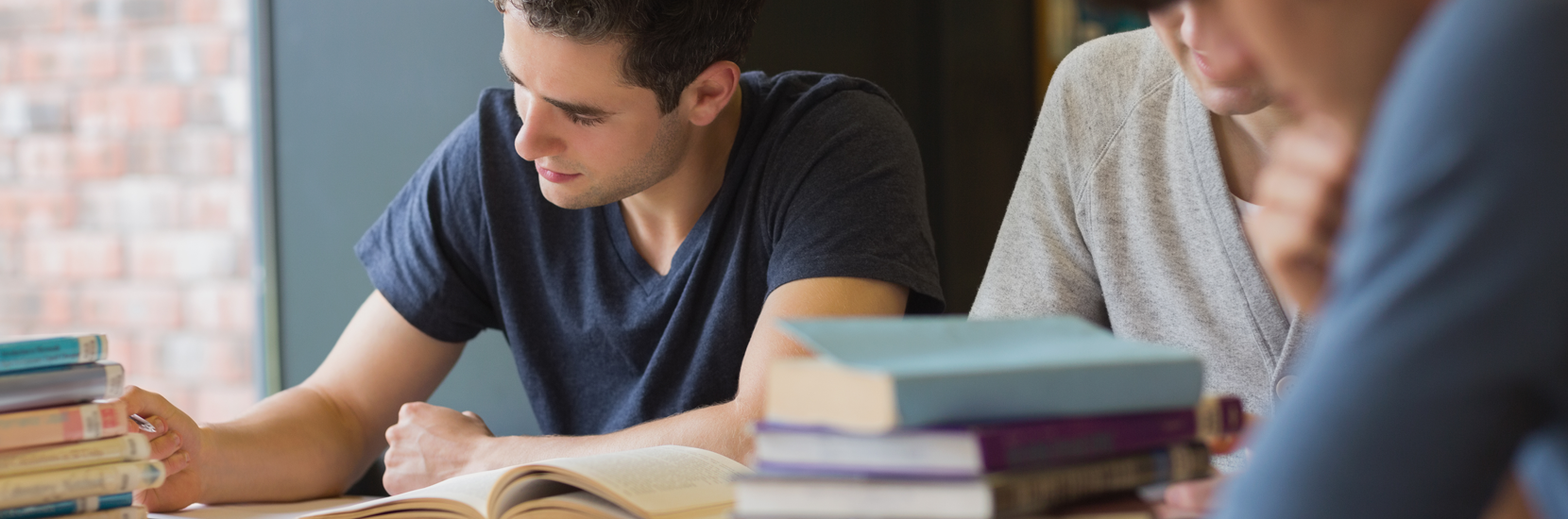 支持服务 Student writing notes in study hall