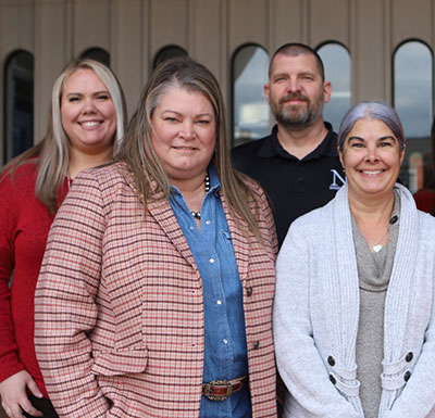Administrator Group of staff standing close together on steps, smiling at the camera