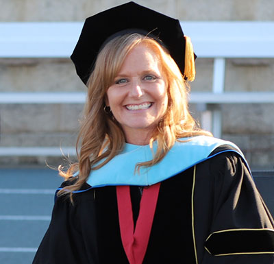 Full-Time Faculty Faculty in full regalia during the Commencement Ceremony, smiling at the camera