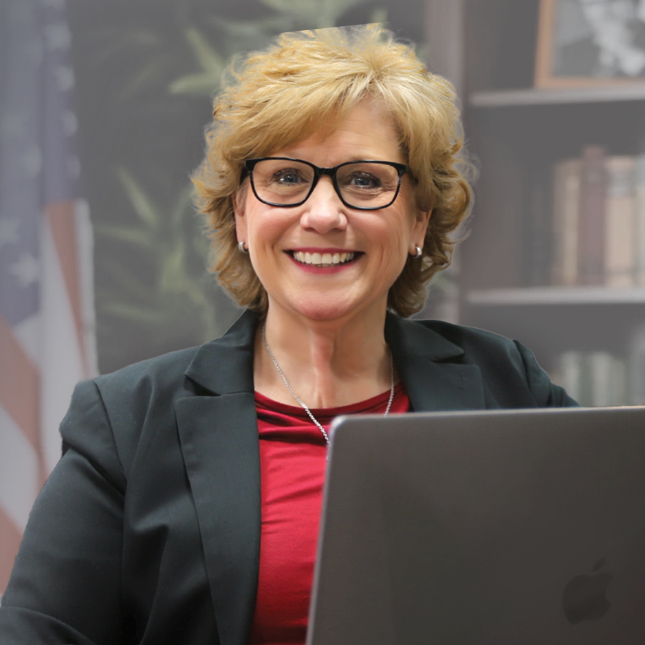 Paralegal Student sitting with laptop, smiling directly at camera