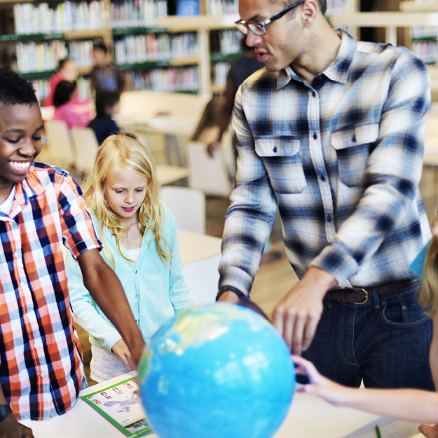 Sociology Teacher showing children book and globe